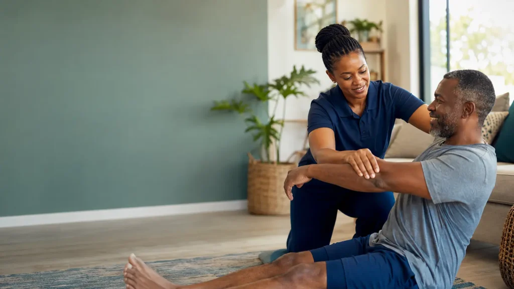 Physiotherapist assisting a patient during a home visit